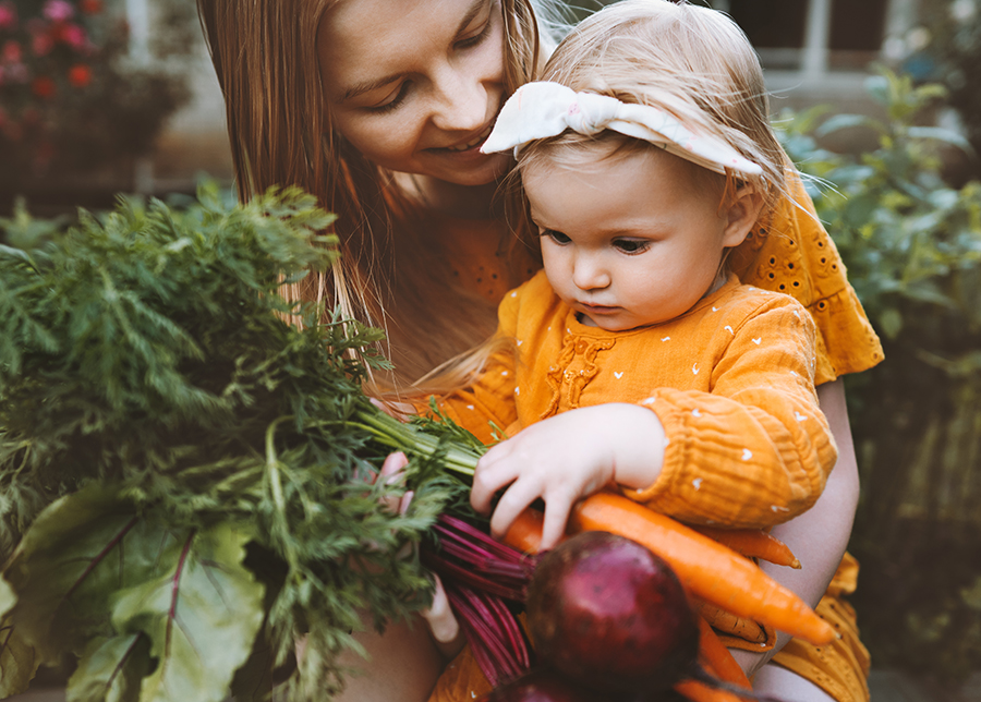 Mother and daughter holding organic produce